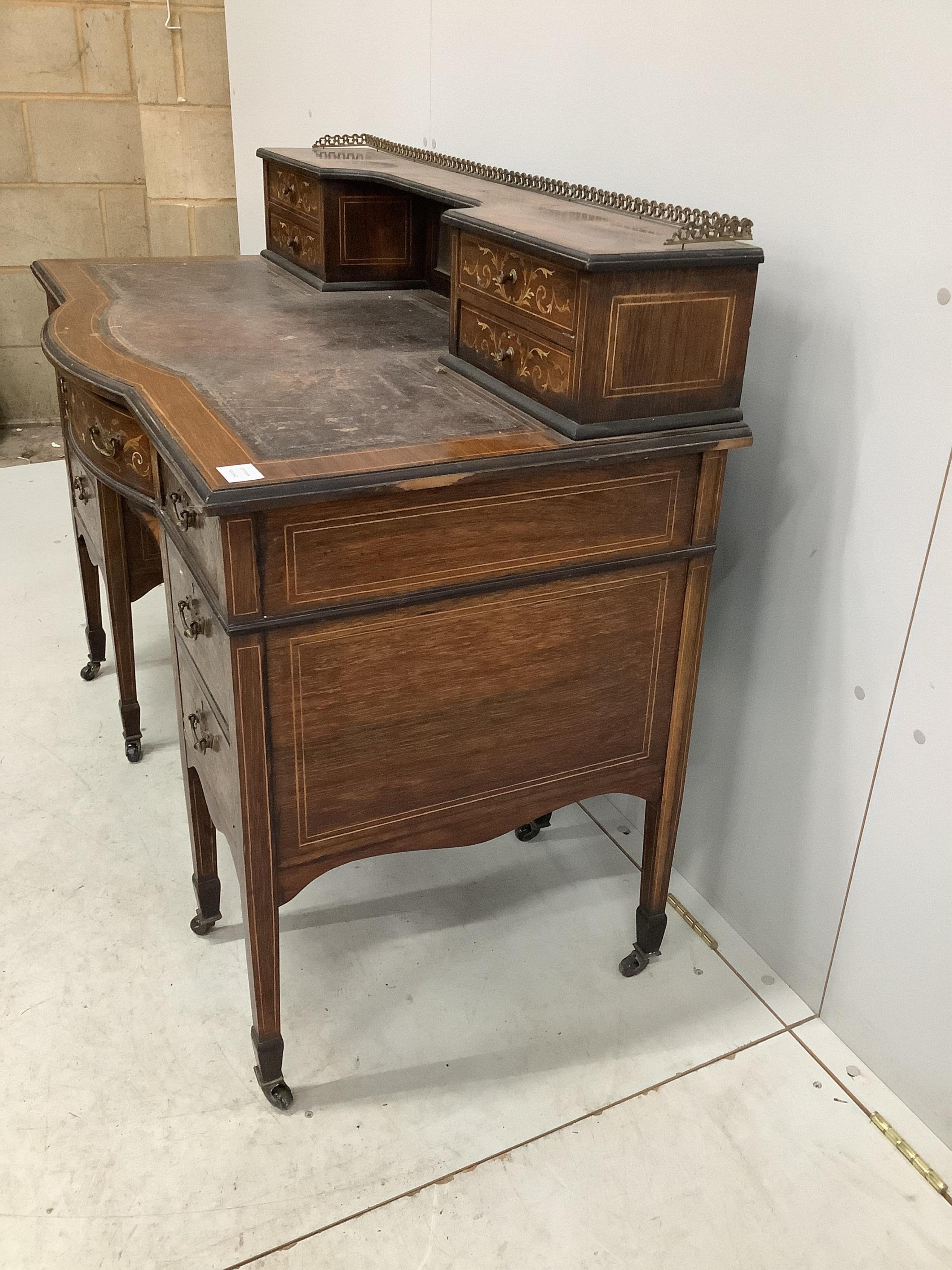 An Edwardian marquetry inlaid rosewood bowfront kneehole desk in the manner of Edwards and Roberts, width 110cm, depth 62cm, height 95cm. Condition - poor to fair